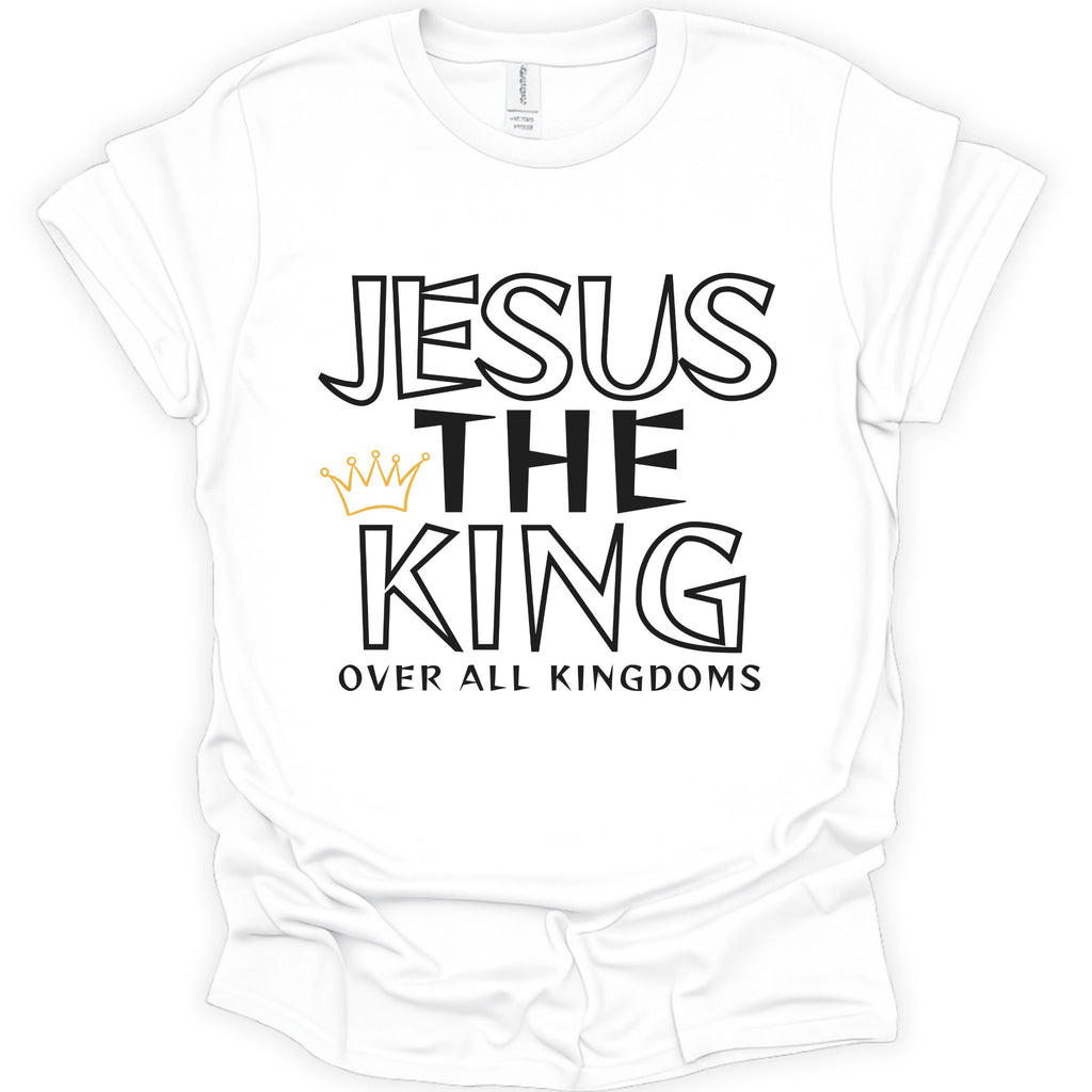 A white short-sleeve crewneck t-shirt with a graphic print reading 'JESUS THE KING OVER ALL KINGDOMS' in black outlined and solid lettering, accented by a small gold crown icon.