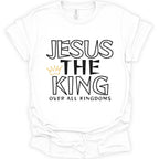 A white short-sleeve crewneck t-shirt with a graphic print reading 'JESUS THE KING OVER ALL KINGDOMS' in black outlined and solid lettering, accented by a small gold crown icon.