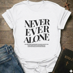 White t-shirt with 'NEVER EVER ALONE' text on a wooden surface with jeans and a Bible. Never Ever Alone Never Forsaken Christian T-Shirt Deuteronomy 31:8 bold faith apparel Faith Forward