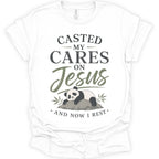 A white short-sleeve crewneck t-shirt with a graphic print on the front. The print features the text 'CASTED MY CARES ON Jesus AND NOW I REST' in dark gray and olive green lettering, accompanied by an illustration of a sleeping panda resting on a rock with bamboo leaves.