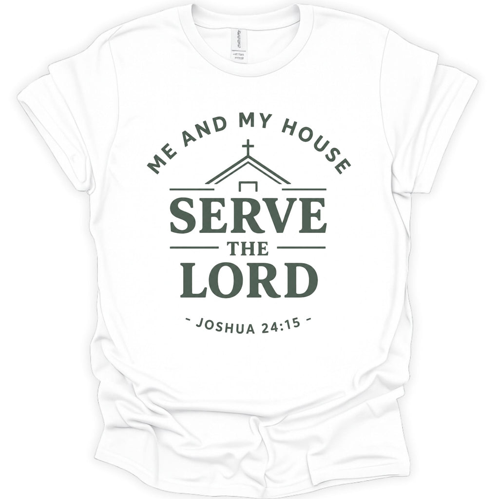 A white short-sleeve crewneck t-shirt with a dark green graphic print on the front. The graphic features a house silhouette with a cross, the words 'ME AND MY HOUSE' arched above, 'SERVE THE LORD' in large bold letters in the center, and '- JOSHUA 24:15 -' curved below.