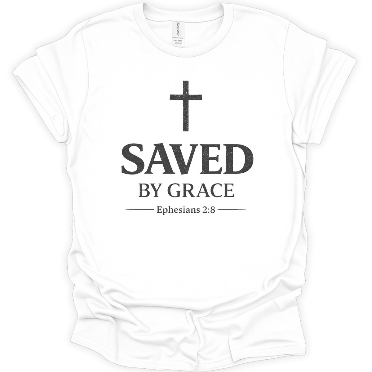 A white short-sleeve crewneck t-shirt with a black graphic print on the front featuring a cross, the text 'SAVED BY GRACE', and 'Ephesians 2:8'.