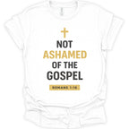 A white short-sleeve crewneck t-shirt with a graphic print on the front. The print features a gold cross above the text 'NOT ASHAMED OF THE GOSPEL' in black and gold lettering, with 'ROMANS 1:16' printed in a gold box at the bottom.