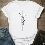 White t-shirt with 'faith' printed on it, placed on a wooden surface with jeans and a Bible. Faith Minimalist Cross Script Christian T-Shirt bold faith apparel Faith Forward