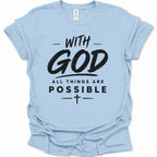 A light blue short-sleeve crewneck t-shirt with a black graphic text print reading 'WITH GOD ALL THINGS ARE POSSIBLE' and a small cross symbol, shown on a plain white background.