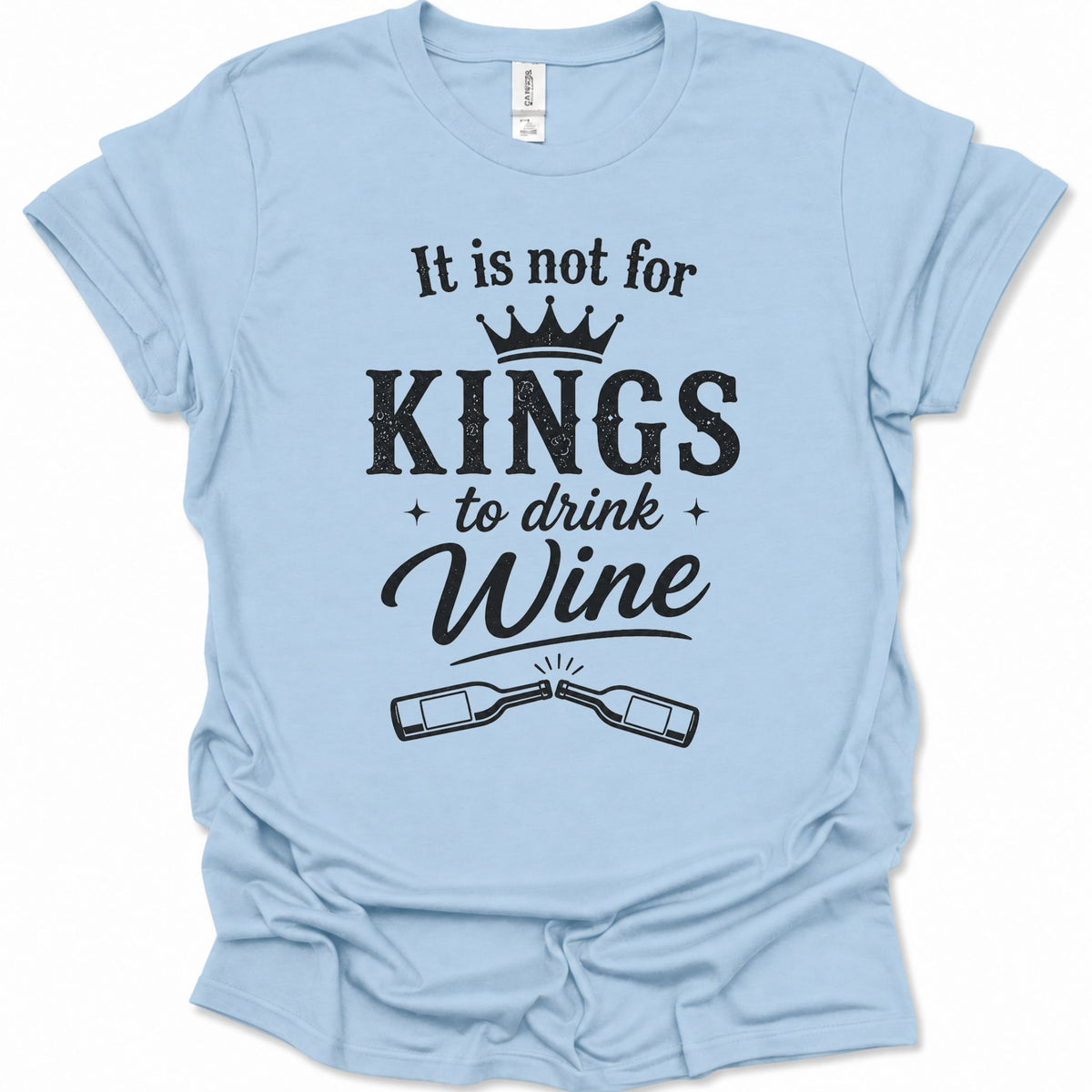 A light blue short-sleeve t-shirt with a black graphic print that reads 'It is not for KINGS to drink Wine' with a crown and two clinking wine bottles, shown on a plain white background.
