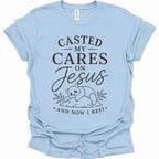 A light blue short-sleeve crewneck t-shirt with a black graphic print on the front. The text reads 'CASTED MY CARES ON Jesus AND NOW I REST' with a simple line drawing of a baby panda resting on a log.