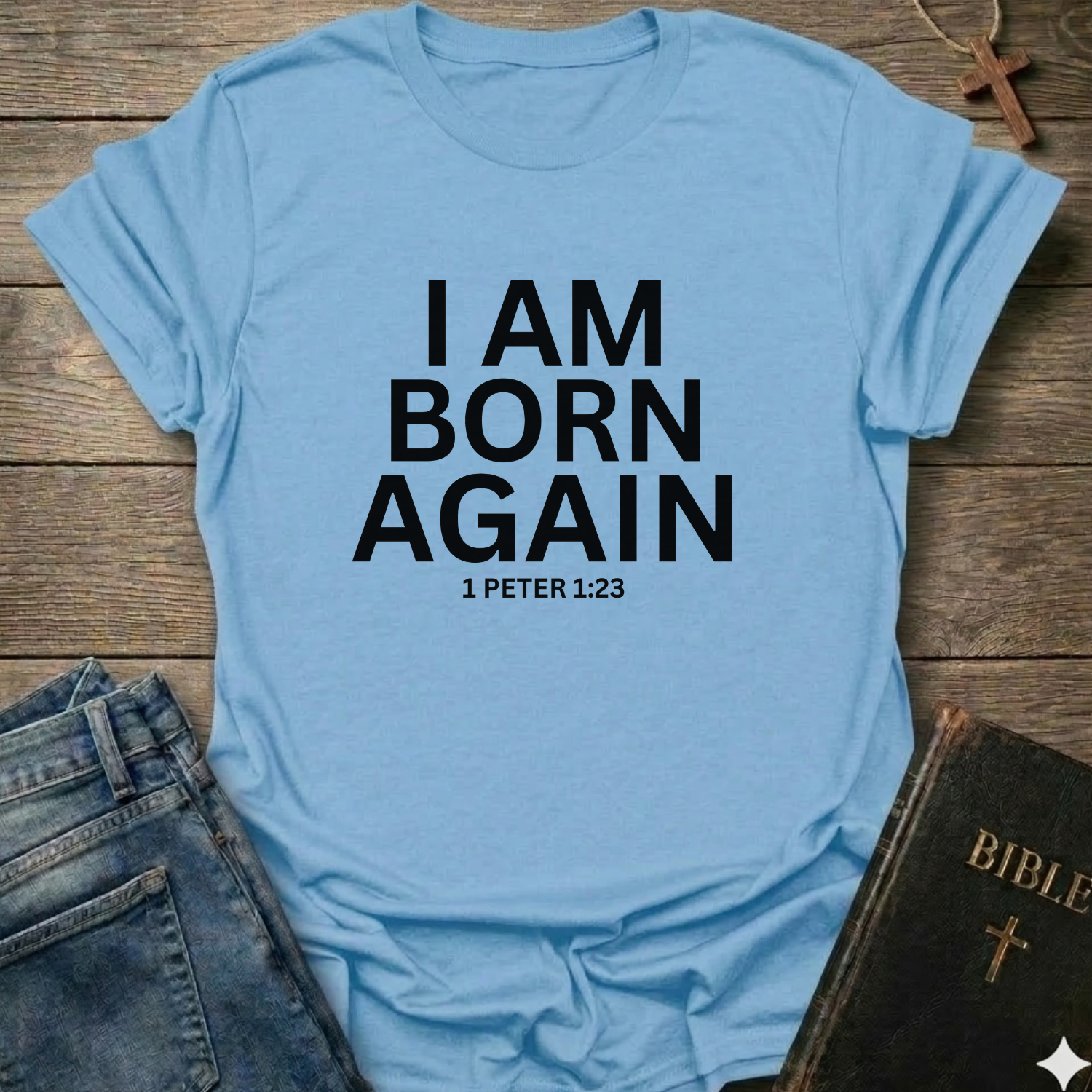 Light blue with 'I AM BORN AGAIN 1 PETER 1:23' text I Am Born Again Christian bold faith apparel conversation starter on a wooden surface with jeans and a Bible.