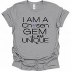 A sport gray short-sleeve t-shirt with a graphic print that reads 'I AM A Chosen GEM I AM UNIQUE' in black lettering, featuring a purple diamond and cross design, displayed on a clean white background.
