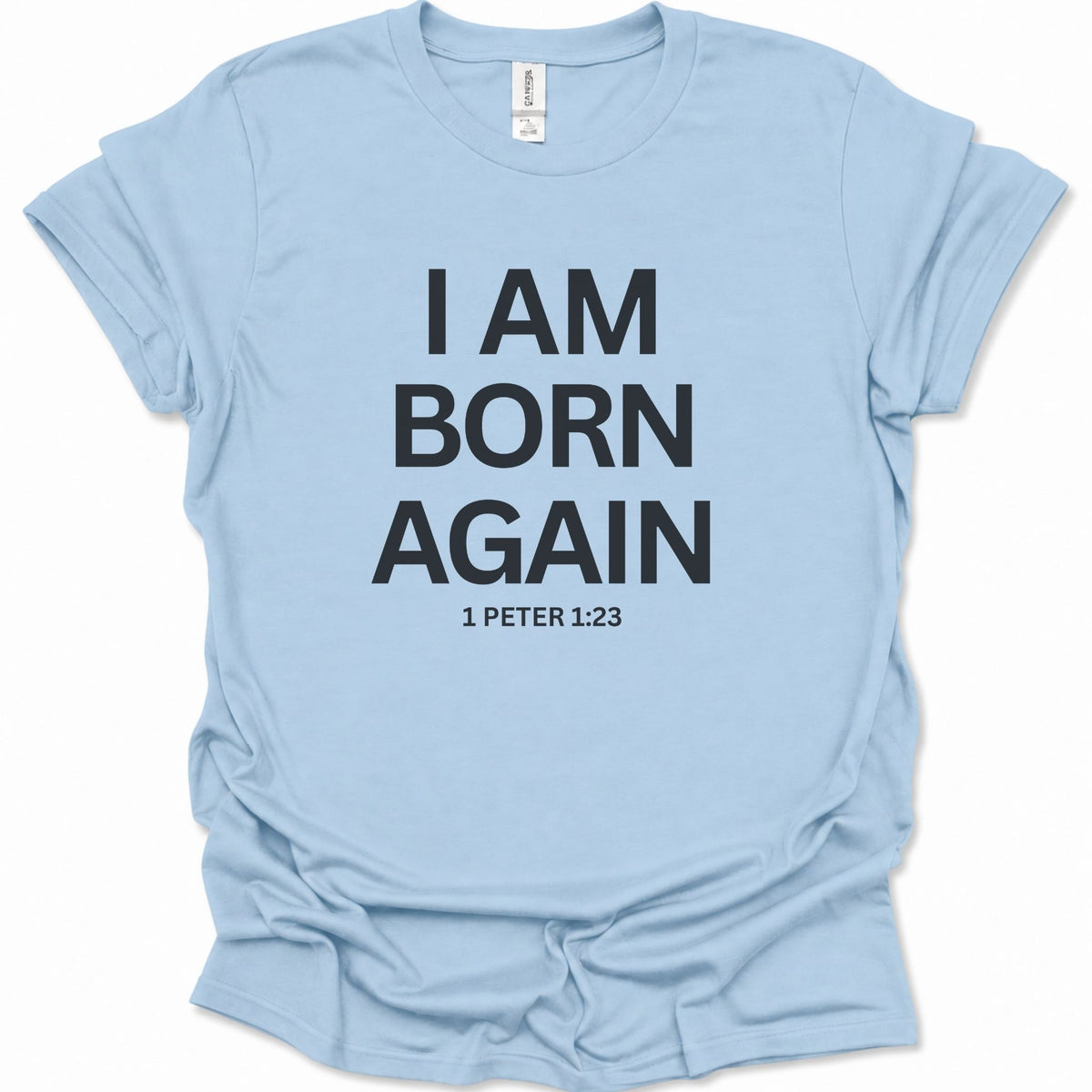 A light blue short-sleeve t-shirt with bold black text reading 'I AM BORN AGAIN' and '1 PETER 1:23' printed on the front, displayed flat against a white background.