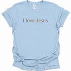 A light blue short-sleeve crewneck t-shirt with the phrase 'I love Jesus' printed across the chest in a brown serif font. The shirt is laid flat against a clean white background, showing a slightly wrinkled texture.