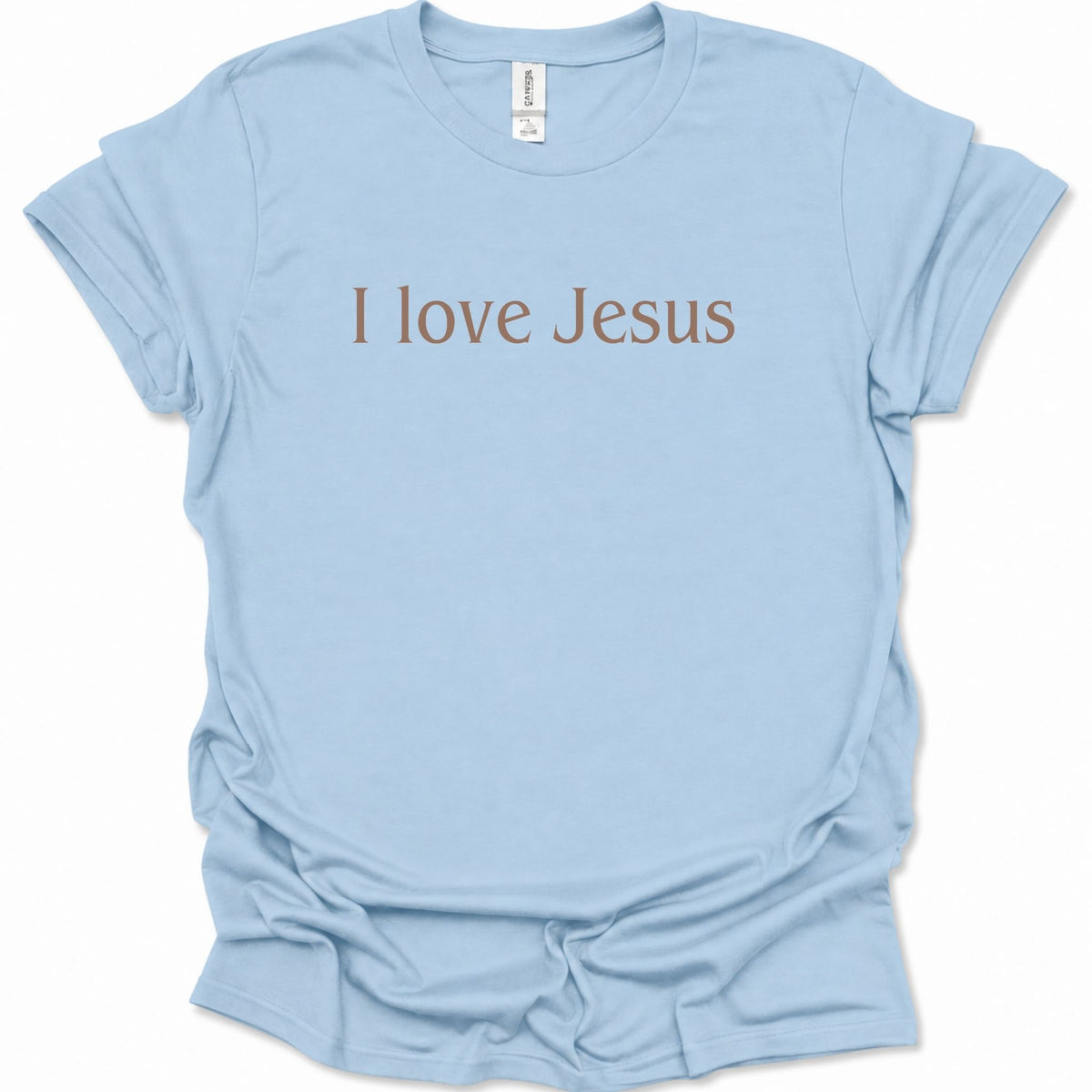 A light blue short-sleeve crewneck t-shirt with the phrase 'I love Jesus' printed across the chest in a brown serif font. The shirt is laid flat against a clean white background, showing a slightly wrinkled texture.