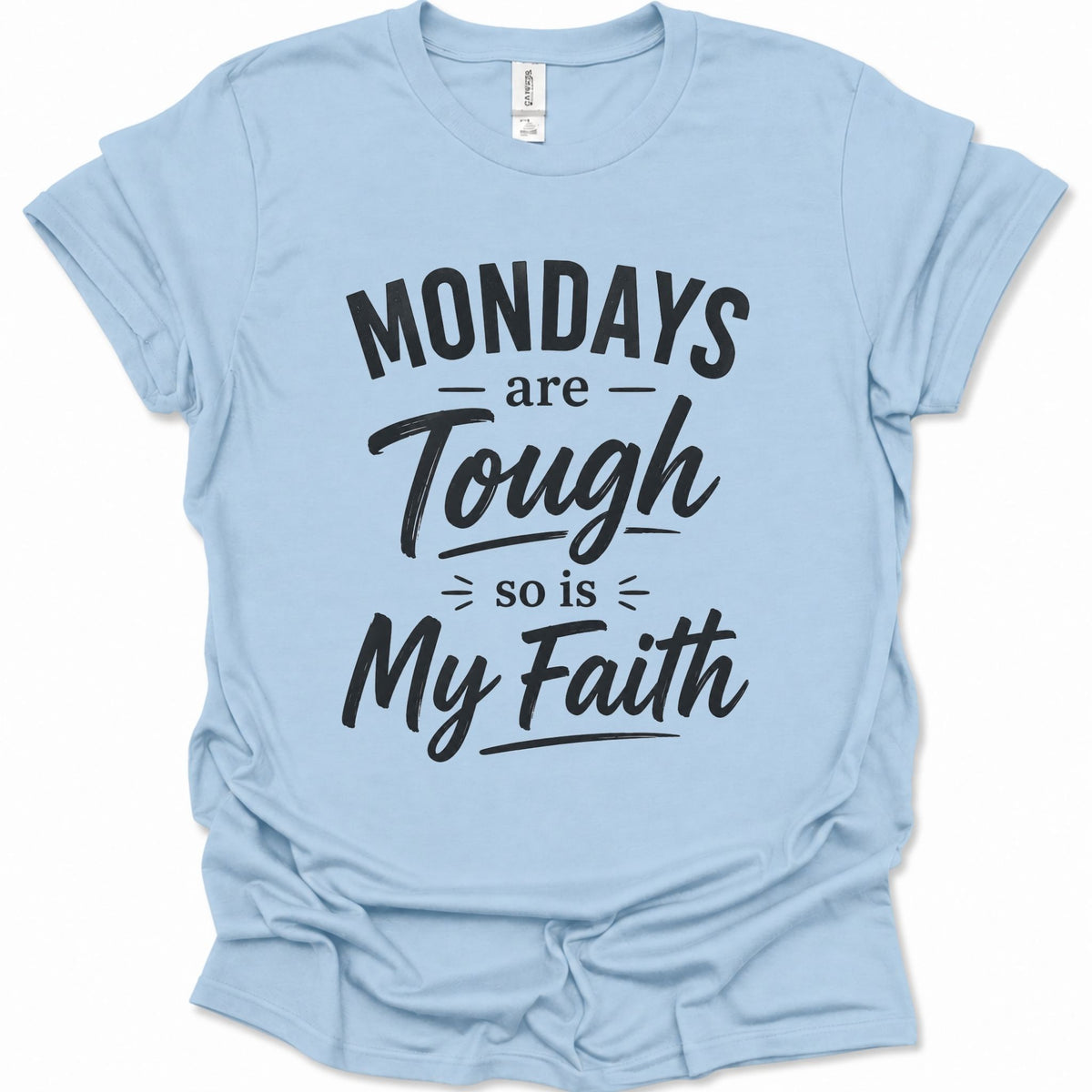 A light blue short-sleeve t-shirt with a black graphic text print reading 'MONDAYS are Tough so is My Faith' on a clean white background.