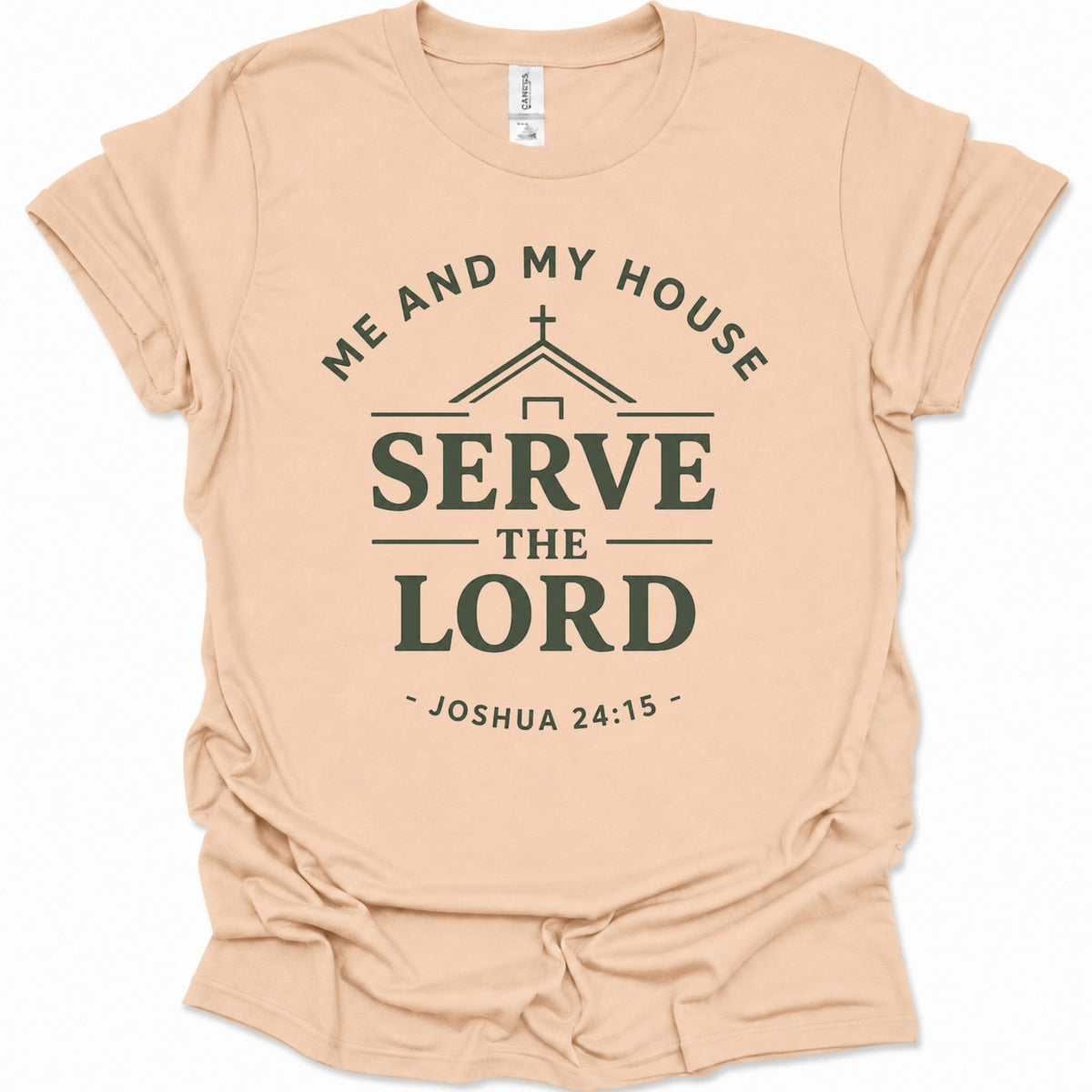 A light natural-colored short-sleeve t-shirt with a dark green graphic print on the front that reads 'ME AND MY HOUSE SERVE THE LORD - JOSHUA 24:15' with a small church icon above the word 'SERVE'.