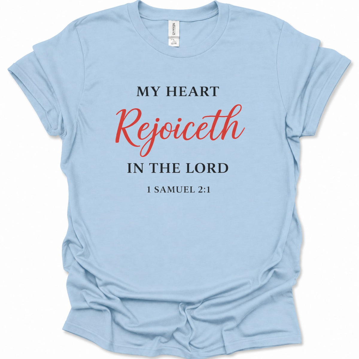 A light blue short-sleeve t-shirt with a printed religious quote on the front reading 'MY HEART Rejoiceth IN THE LORD 1 SAMUEL 2:1' in black and red lettering, shown on a plain white background.