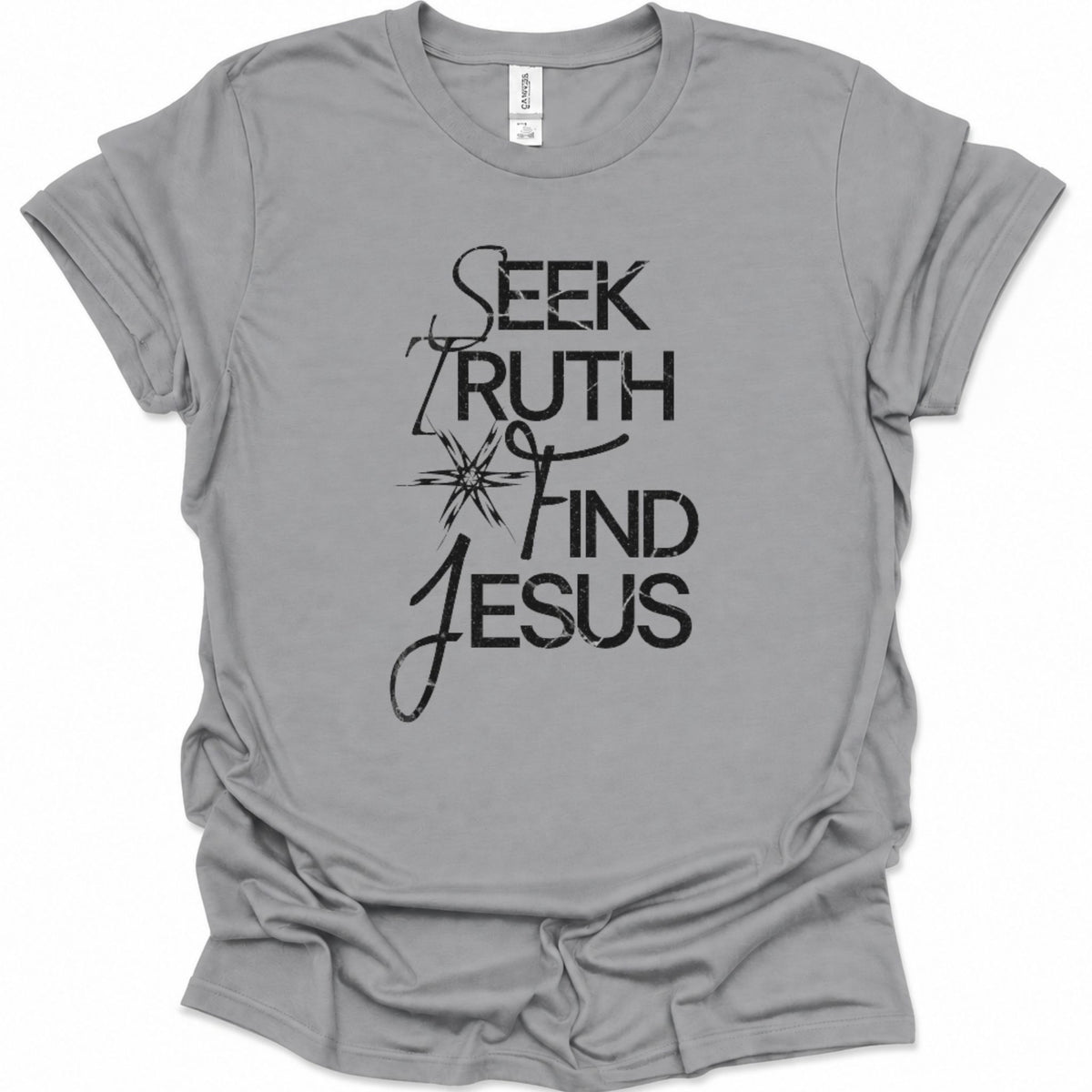 A sport gray short-sleeve t-shirt with a black graphic print on the front reading 'SEEK TRUTH FIND JESUS' with a starburst design, shown on a plain white background.