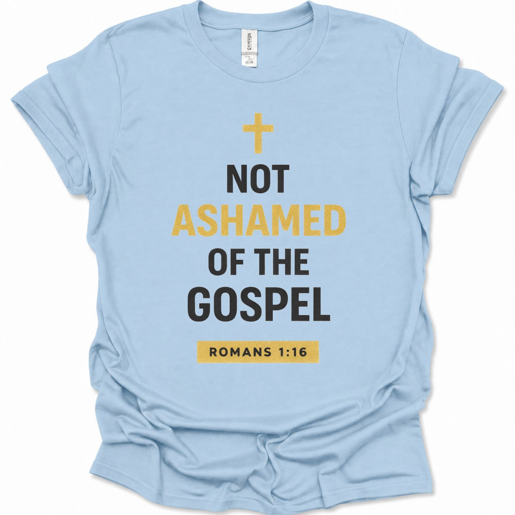 A light blue short-sleeve t-shirt with a graphic print on the front. The print features a yellow cross, the text 'NOT ASHAMED OF THE GOSPEL' in black and yellow, and 'ROMANS 1:16' inside a yellow box at the bottom.