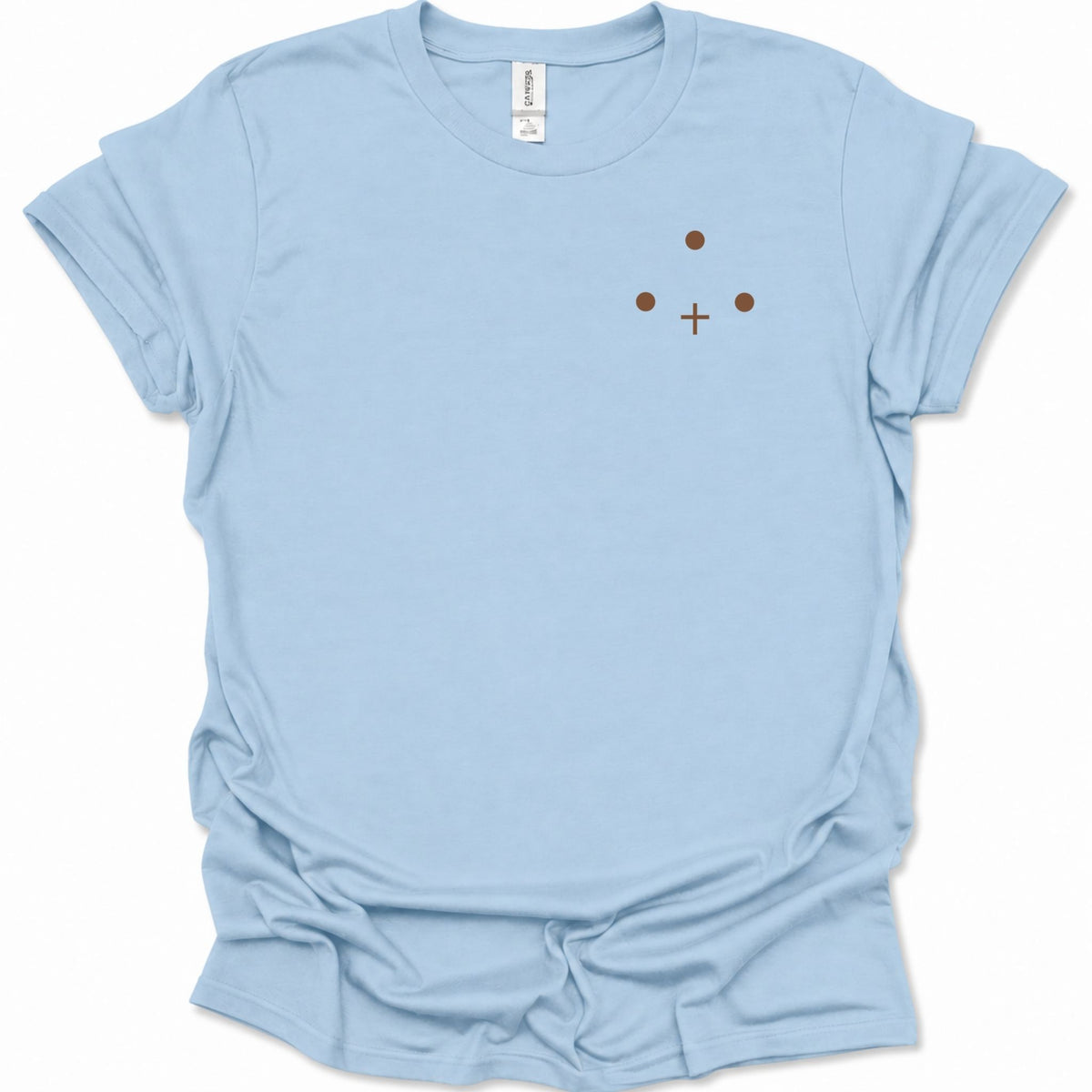 A light blue short-sleeve crewneck t-shirt with a small minimalist graphic on the left chest consisting of three brown dots and a brown cross, displayed on a clean white background.