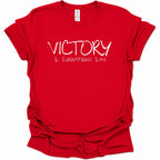 A bright red short-sleeve t-shirt with 'VICTORY 2 CORINTHIANS 2:14' printed in white across the chest, displayed on a clean white background.