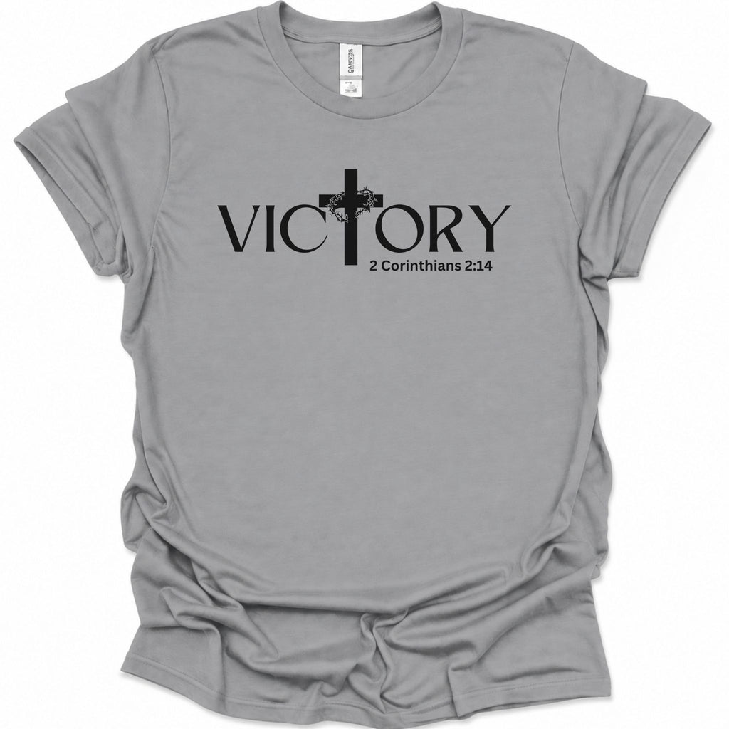 A sport gray short-sleeve t-shirt with a black graphic print on the front reading 'VICTORY' with a cross and '2 Corinthians 2:14' underneath, shown on a plain white background.