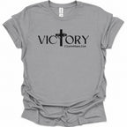 A sport gray short-sleeve t-shirt with a black graphic print on the front reading 'VICTORY' with a cross and '2 Corinthians 2:14' underneath, shown on a plain white background.