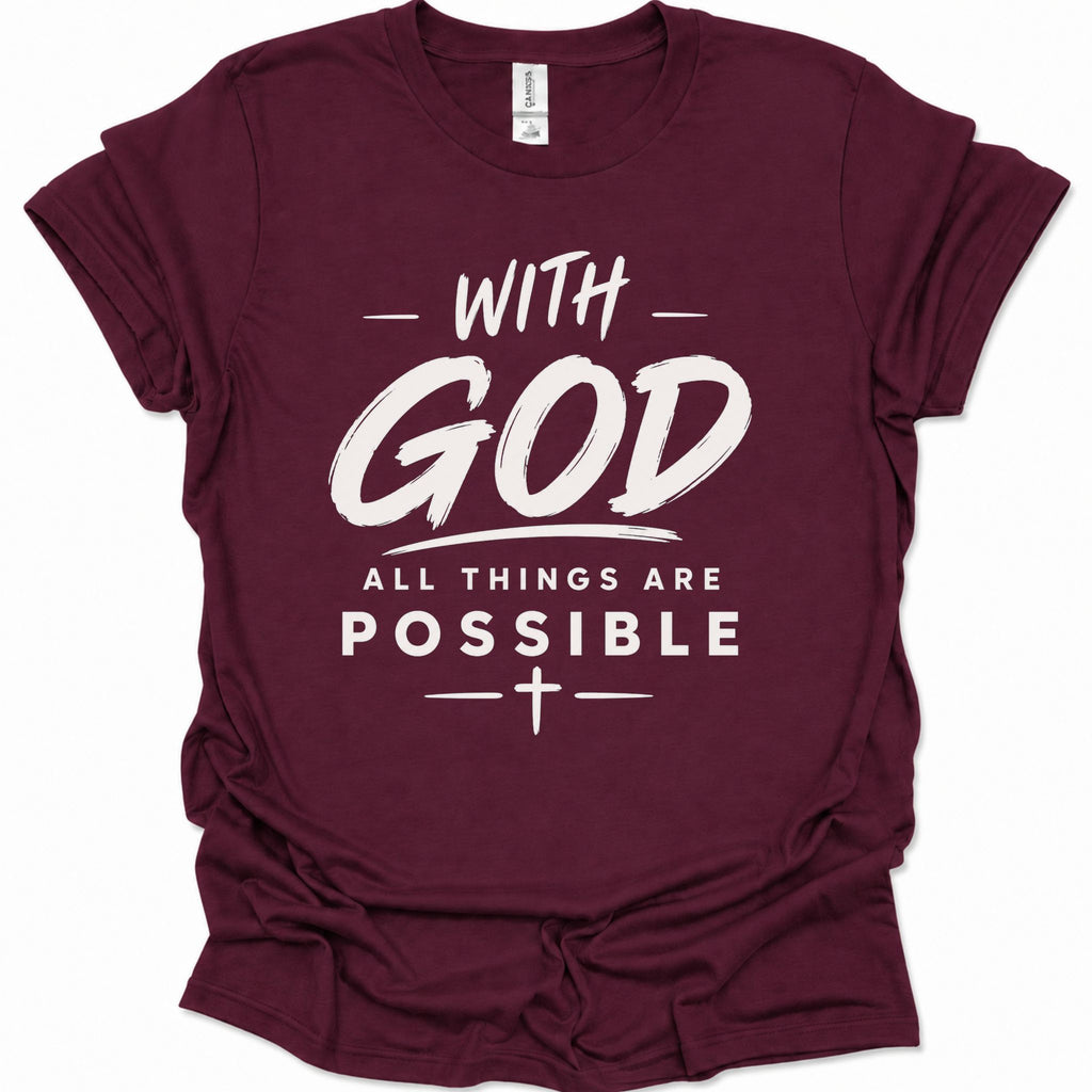 A maroon short-sleeve crewneck t-shirt with a white graphic text print reading 'WITH GOD ALL THINGS ARE POSSIBLE' and a cross symbol, shown on a plain white background.