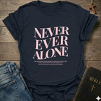 Navy blue t-shirt with 'Never Ever Alone' text on a wooden surface with jeans and a Bible. Never Ever Alone Never Forsaken Christian T-Shirt Deuteronomy 31:8 bold faith apparel Faith Forward