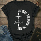 Black t-shirt with a cross and text  "Jesus The Way The Truth The Life Cross Circle John 14:6" Christian faith apparel Faith Forward. It is on a wooden surface with jeans and a Bible.