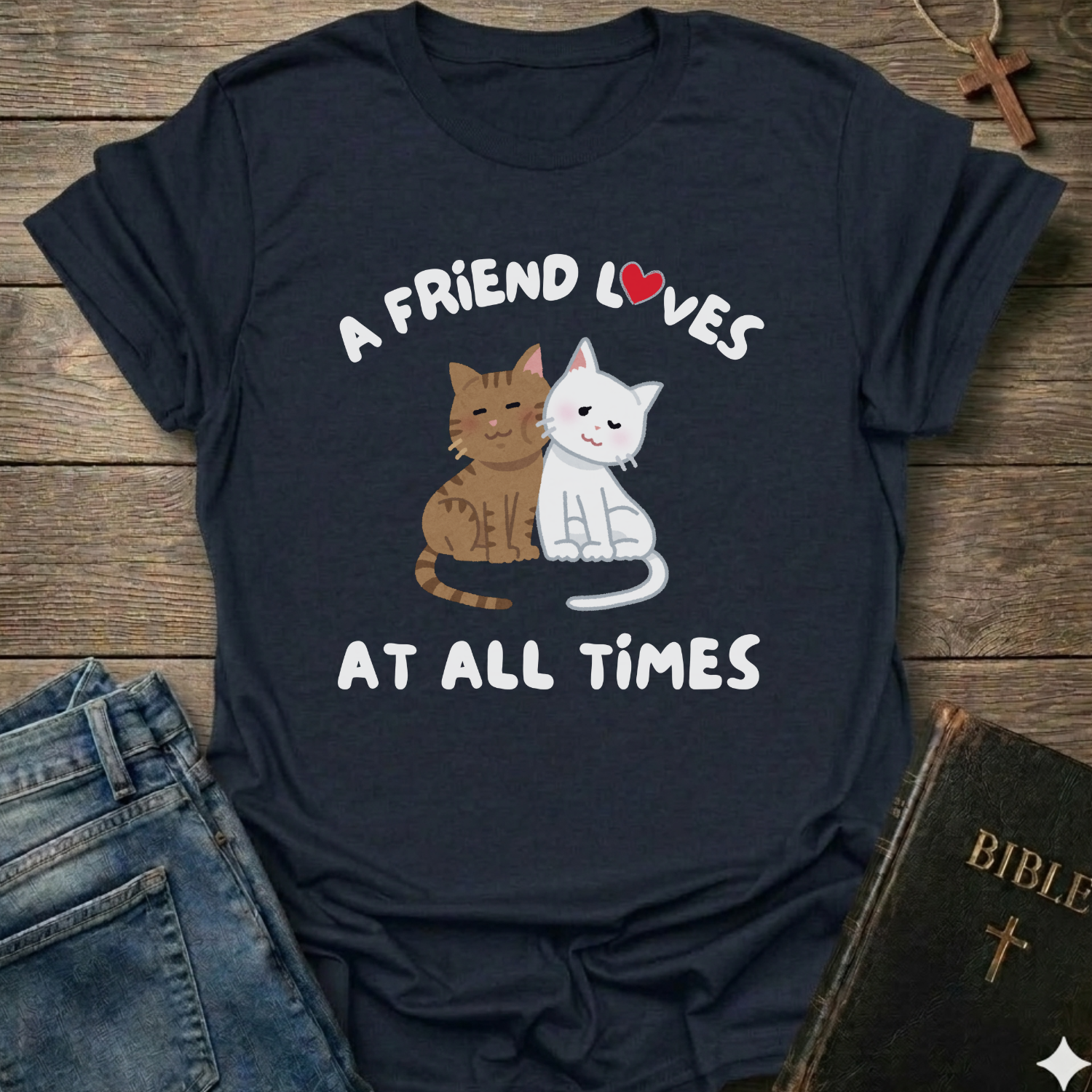 Navy blue t-shirt with cat graphic and text A Friend Loves at All Times Christian T-Shirt illustrated Proverbs 17:17 faith apparel conversation starter
on a wooden surface
