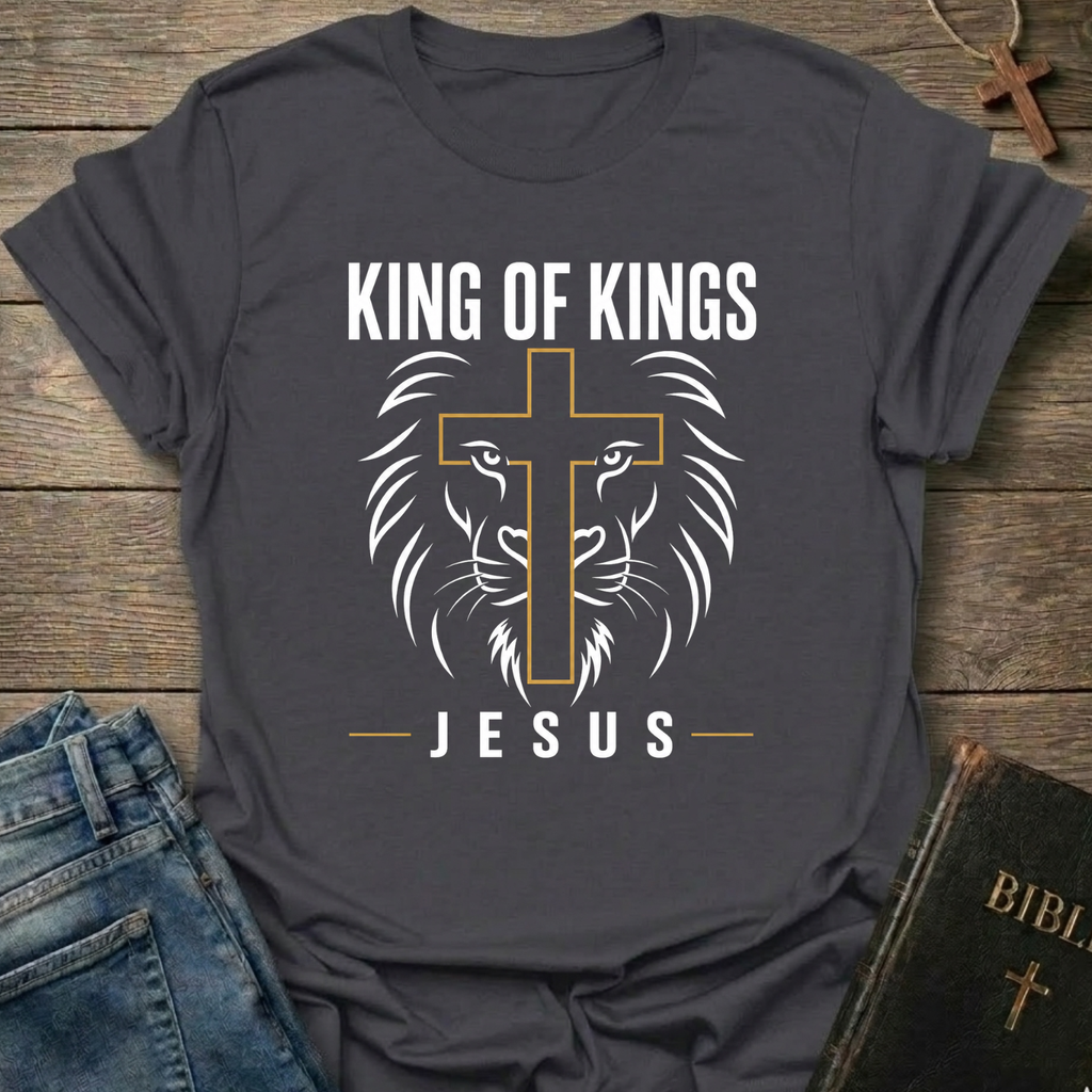 Gray t-shirt with 'King of Kings Jesus Lion Cross Revelation 19:16 faith apparel conversation starter' on a wooden surface. 