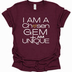 A maroon short-sleeve t-shirt with a white graphic text print reading 'I AM A Chosen GEM I AM UNIQUE' and a small gold diamond icon, shown on a plain white background.