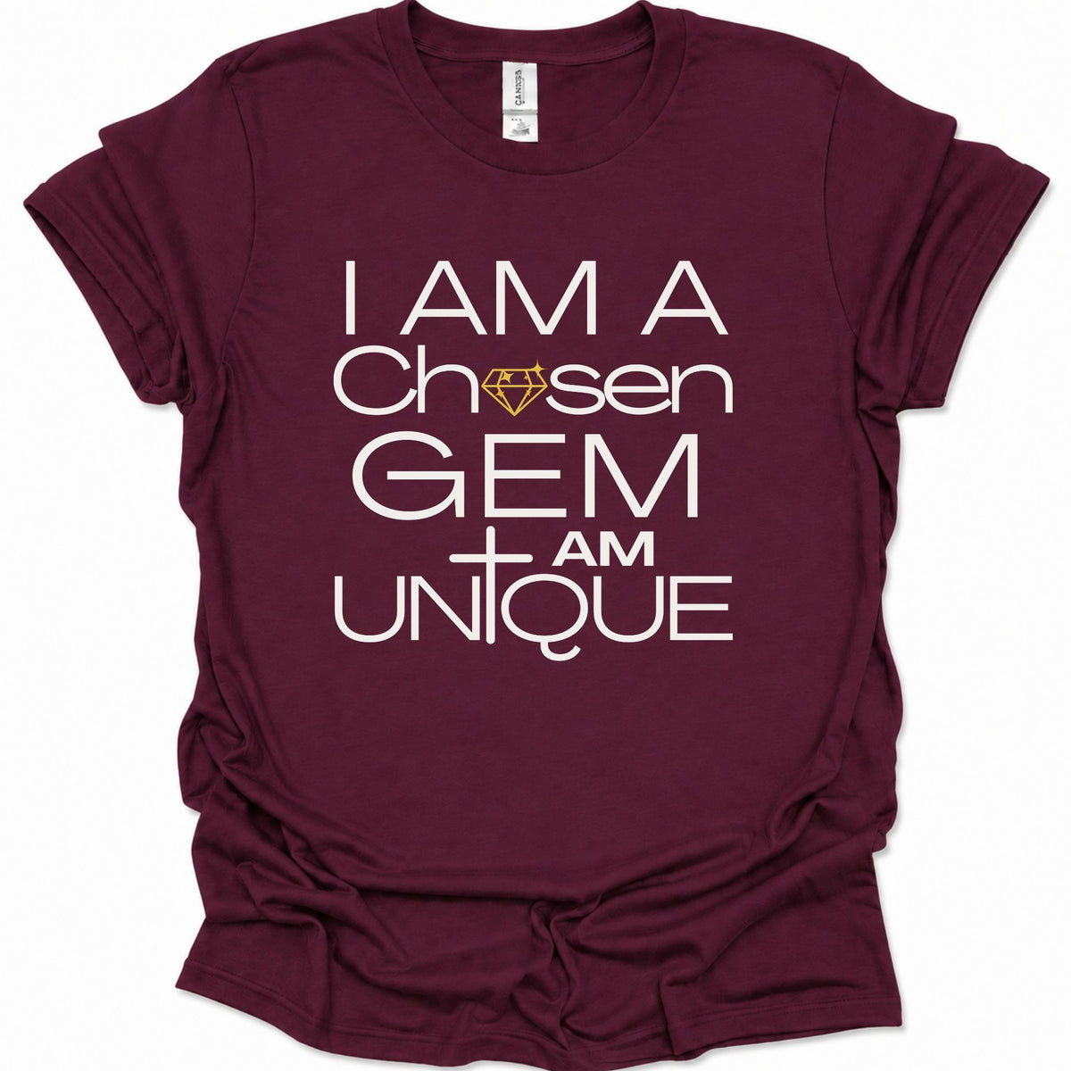 A maroon short-sleeve t-shirt with a white graphic text print reading 'I AM A Chosen GEM I AM UNIQUE' and a small gold diamond icon, shown on a plain white background.