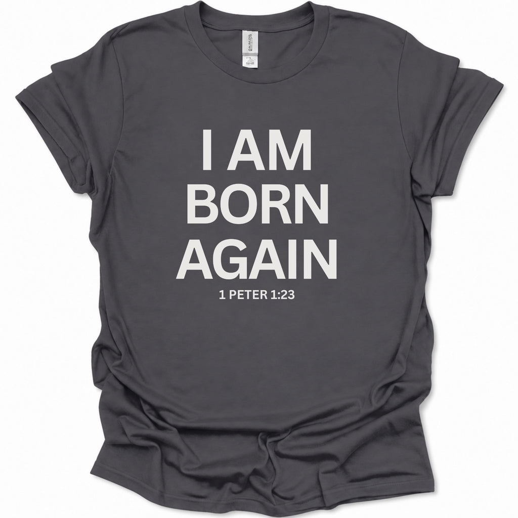 A dark heather gray short-sleeve t-shirt with bold white text reading 'I AM BORN AGAIN' and '1 PETER 1:23' printed on the front, shown on a plain white background.