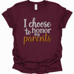 A maroon short-sleeve t-shirt with a graphic text print reading 'I choose to honor my parents' in white and gold lettering, displayed on a clean white background.