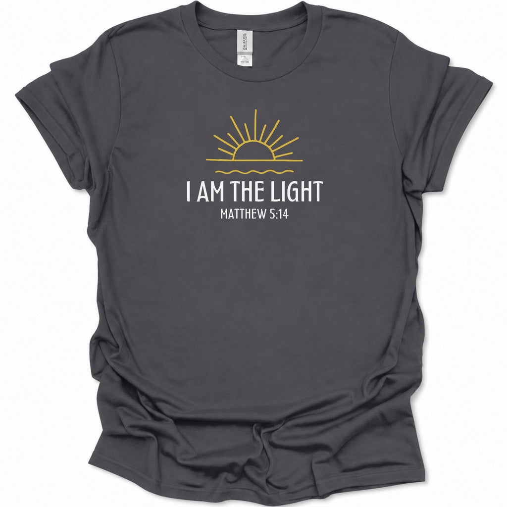 A dark heather gray short-sleeve t-shirt with a graphic print of a yellow rising sun and the text 'I AM THE LIGHT MATTHEW 5:14' in white and yellow, displayed on a clean white background.