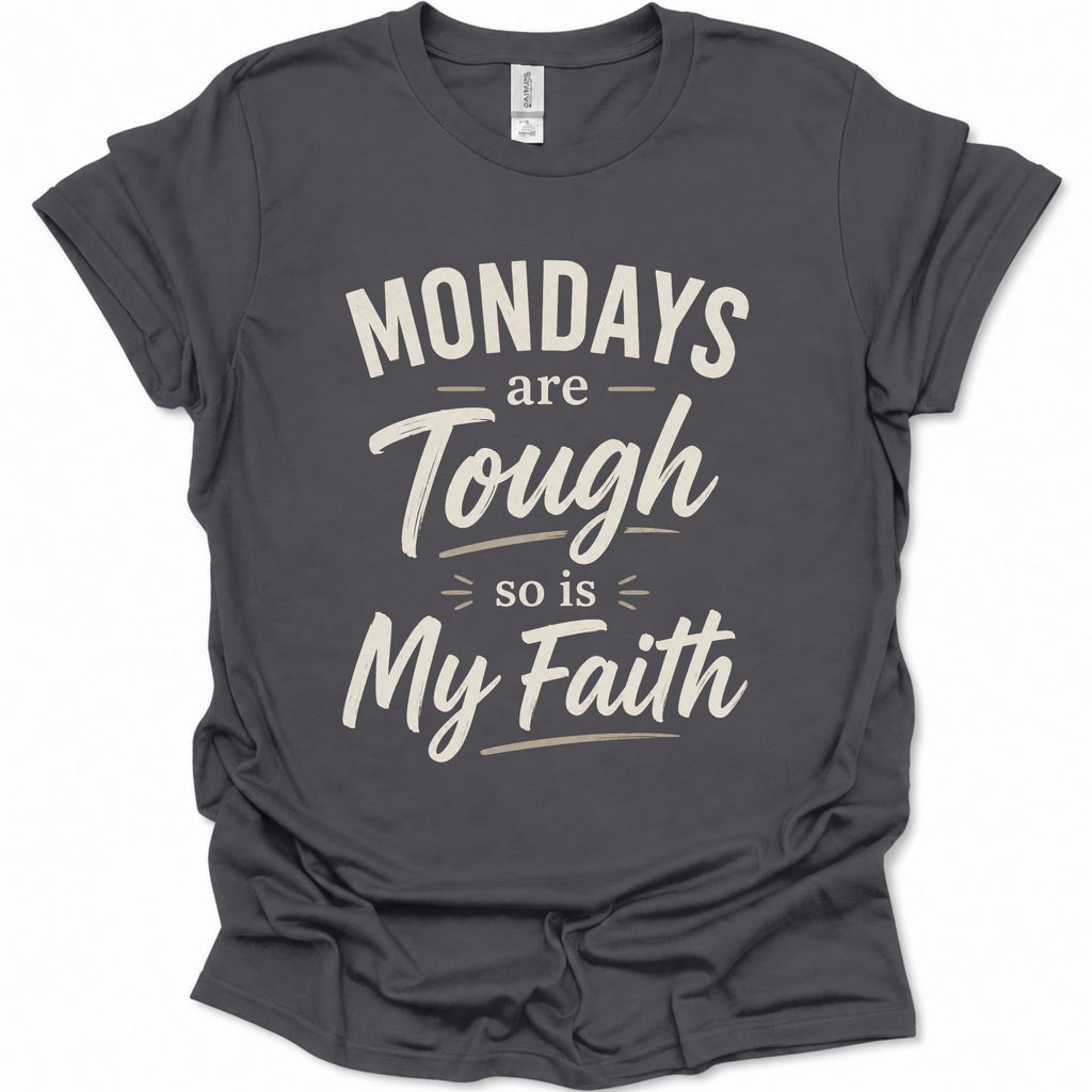 A dark heather gray short-sleeve t-shirt with a distressed cream-colored graphic text that reads 'MONDAYS are Tough so is My Faith'. The t-shirt is displayed flat against a clean white background.