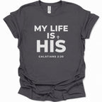 A dark heather gray short-sleeve t-shirt with a white printed text graphic reading 'MY LIFE IS HIS GALATIANS 2:20' on the front, displayed against a plain white background.