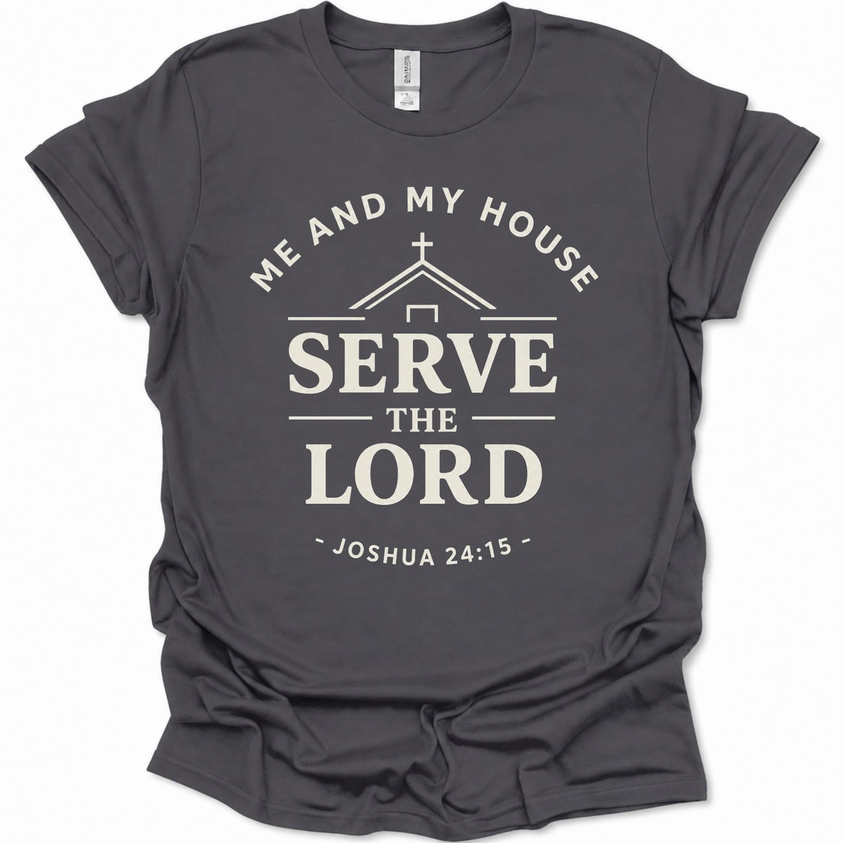A dark heather gray short-sleeve t-shirt with a cream-colored graphic print that reads 'ME AND MY HOUSE SERVE THE LORD - JOSHUA 24:15' with a house silhouette and cross.