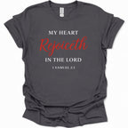 A dark heather gray short-sleeve t-shirt with a printed religious quote on the front reading 'MY HEART Rejoiceth IN THE LORD 1 SAMUEL 2:1' in white and red lettering, shown against a plain white background.