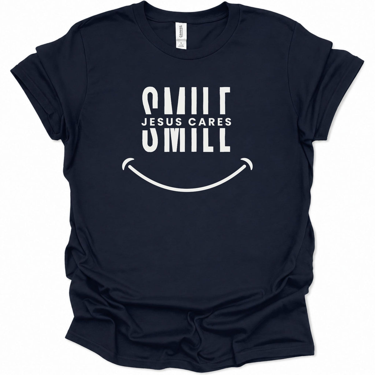 A navy blue short-sleeve t-shirt with a white graphic print on the front that reads 'SMILE JESUS CARES SMILL' above a smiley face, shown on a plain white background.
