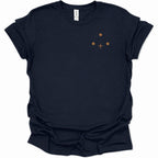 A navy blue short-sleeve t-shirt with a small minimalist graphic on the left chest consisting of three brown dots and a brown cross, displayed on a clean white background.