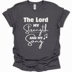 A dark heather gray short-sleeve t-shirt with a white graphic print that reads 'The Lord My Strength And My Song' with a music note, displayed on a clean white background.