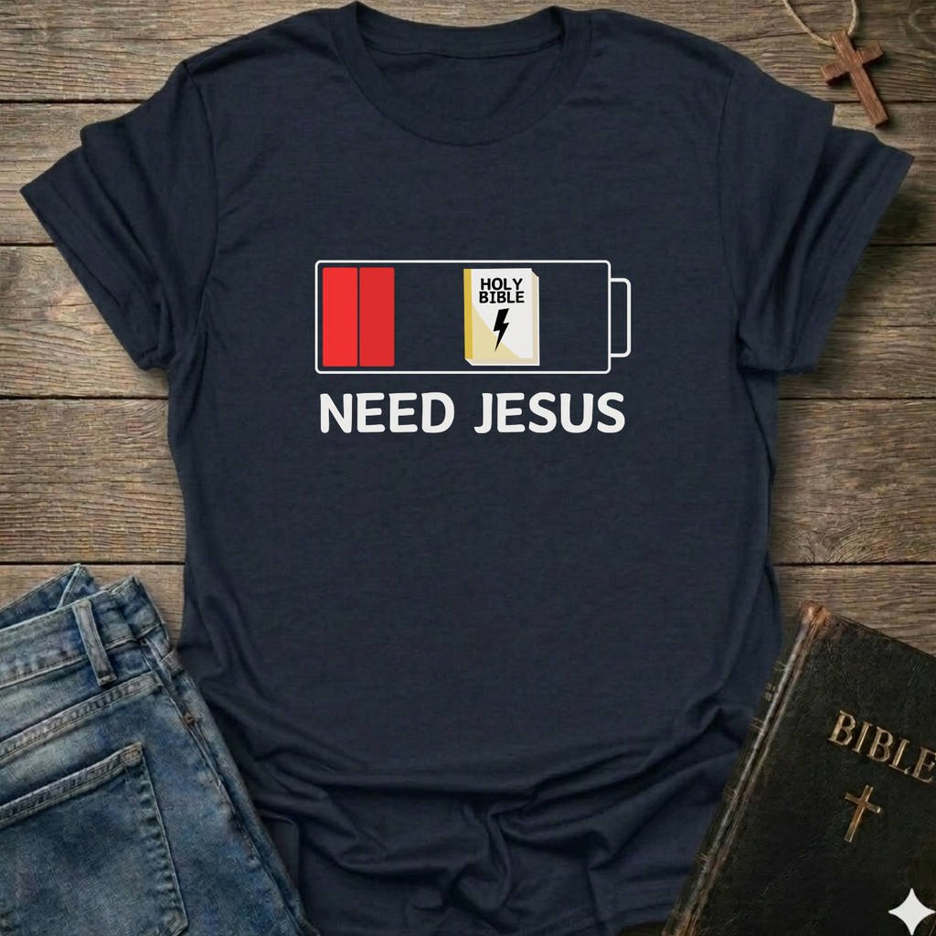 Black t-shirt with 'Need Jesus' graphic on a wooden surface with jeans and a Bible. Need Jesus to Recharge My Battery Christian T-Shirt bold faith apparel Faith Forward