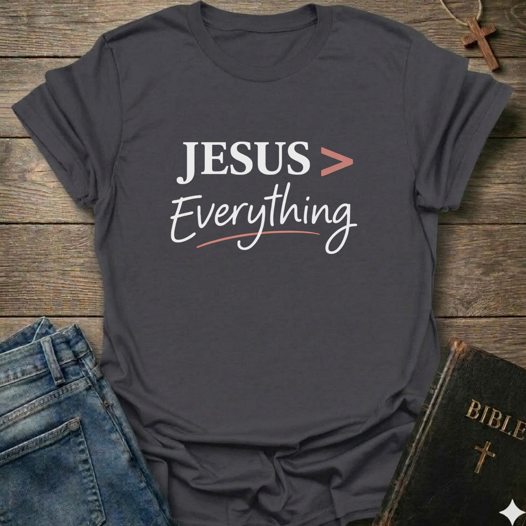 Gray T-Shirt faith apparel conversation starter with 'JESUS > Everything' text on a wooden surface with jeans and a Bible.