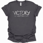 A dark heather gray short-sleeve t-shirt with 'VICTORY 2 CORINTHIANS 2:14' printed in white across the chest, displayed on a clean white background.