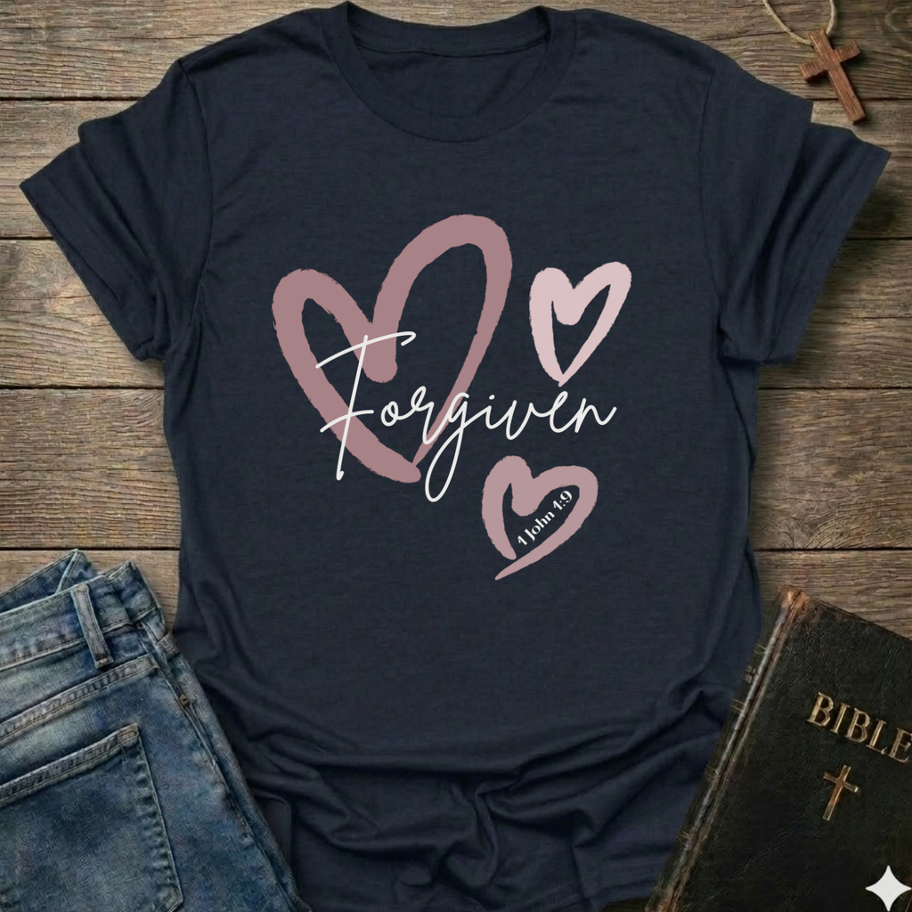 Navy blue t-shirt with 'Forgiven' text and pink hearts on a wooden surface with jeans and a Bible. Forgiven Christian T-Shirt 1 John 1:9 bold faith apparel Faith Forward women