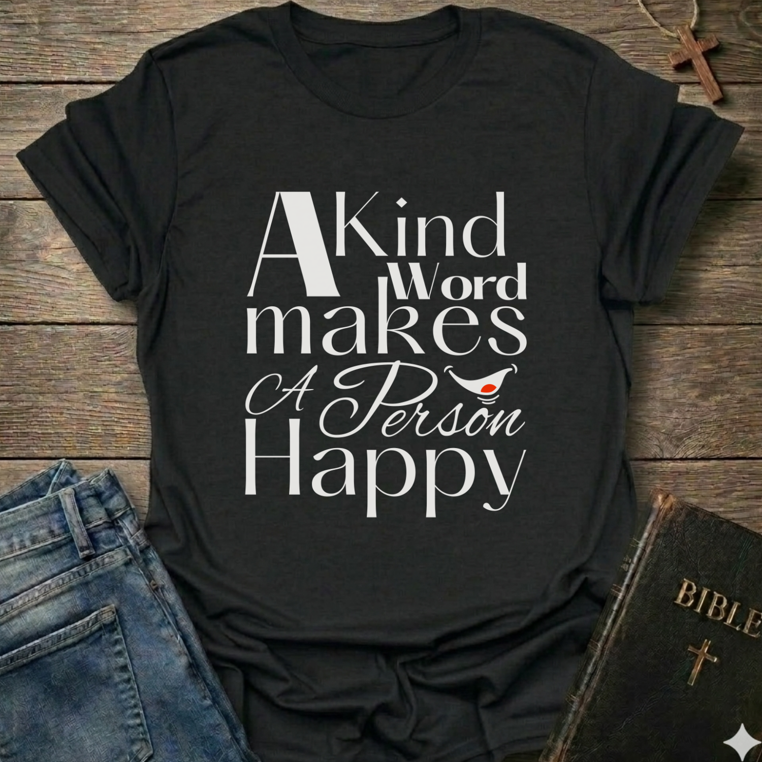 Black t-shirt with 'A Kind Word makes A Person Happy' Proverbs 12:25 text with a smile. Christian elegant typography faith apparel conversation starter
on a wooden surface with jeans and a Bible.