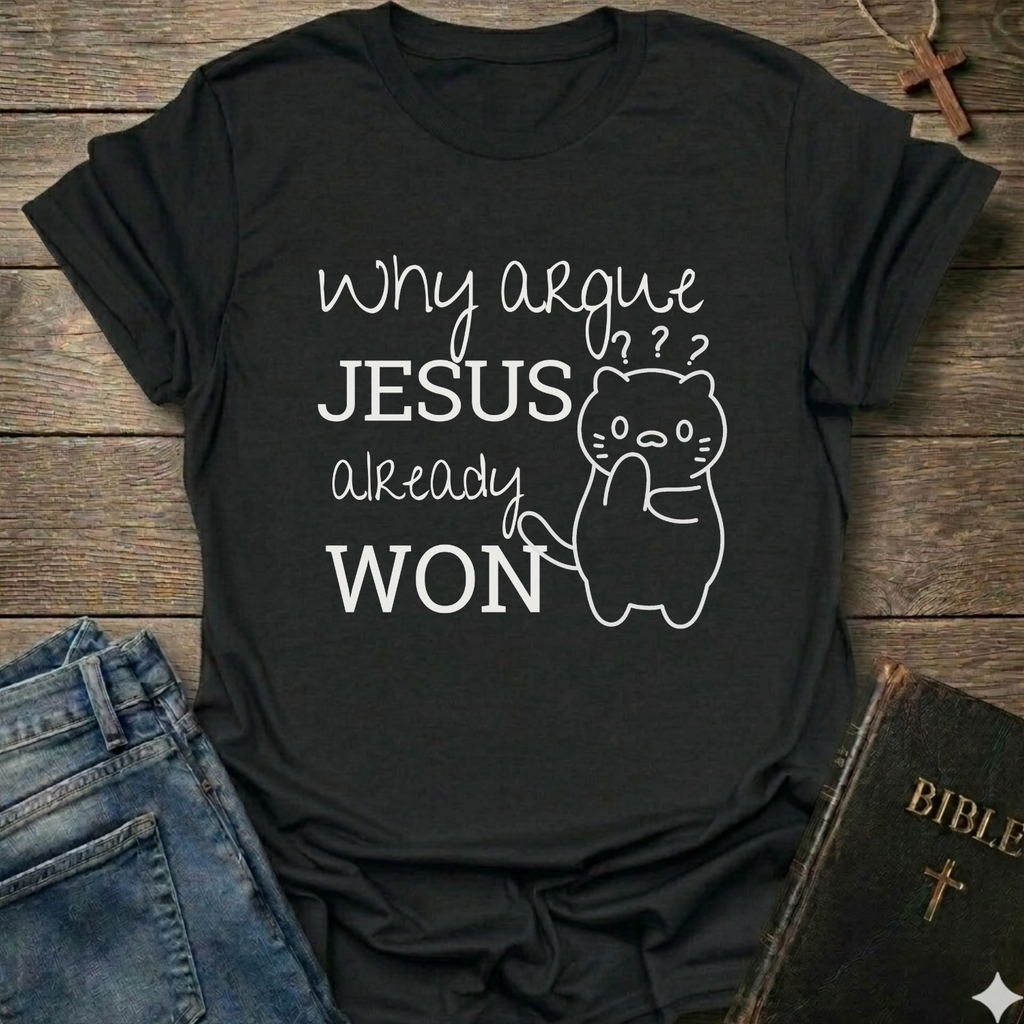 A black graphic t-shirt laid flat on a rustic wooden background, styled with blue jeans, a Bible, and a wooden cross. The t-shirt features the white printed text 'Why argue JESUS already WON' alongside a simple line drawing of a confused cat.