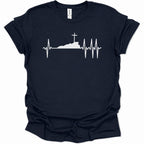 A navy blue short-sleeve t-shirt with a white graphic print of a heartbeat EKG line forming a silhouette of a hill with a cross on top, displayed on a clean white background.
