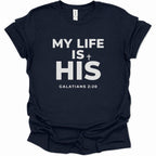 A navy blue short-sleeve t-shirt with white printed text reading 'MY LIFE IS HIS' and 'GALATIANS 2:20' on the front, shown against a plain white background.